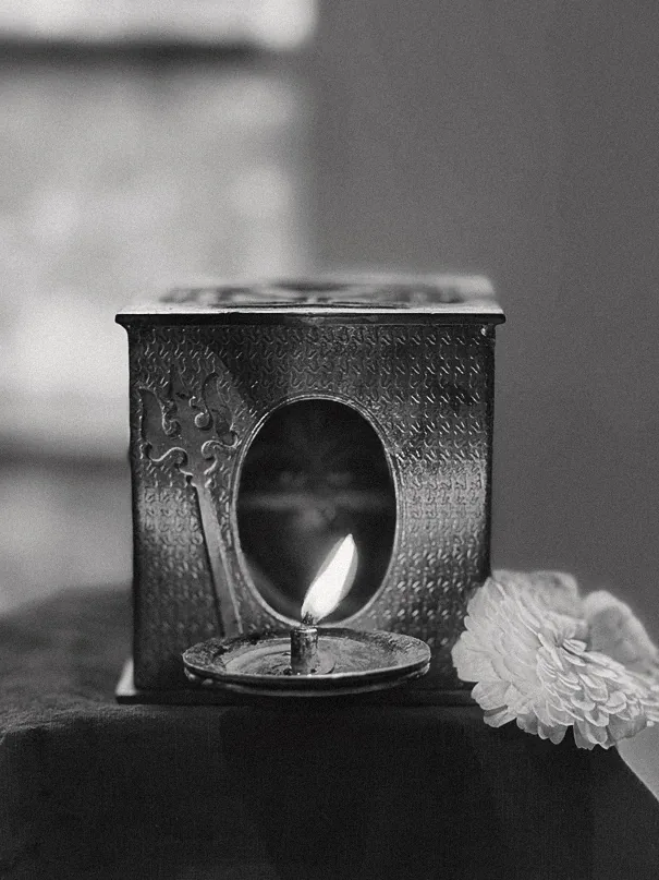 Black and white brass diya lantern with a flame