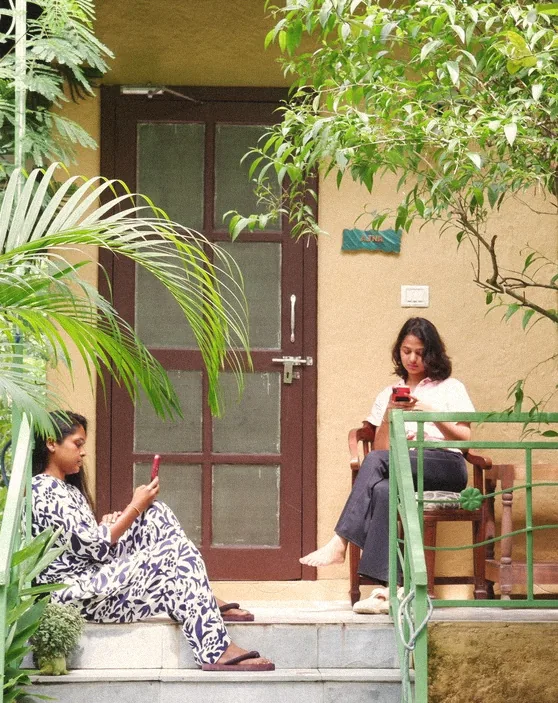 Two guests reading on the steps of a cottage door