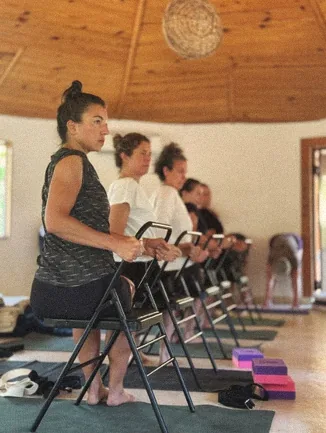 Students practising chair-supported yoga in the yoga hall