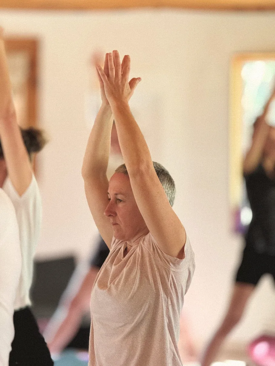 Students reaching arms overhead in a hatha yoga class
