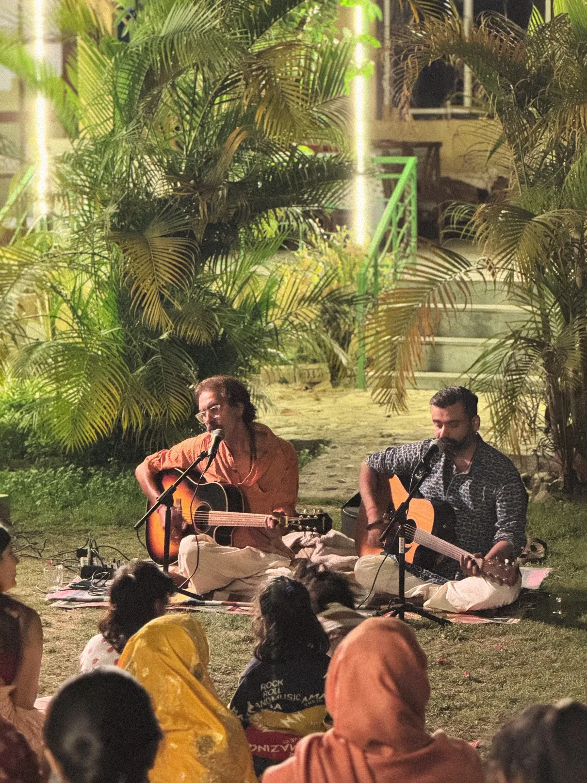 Evening kirtan with two guitarists singing in the garden