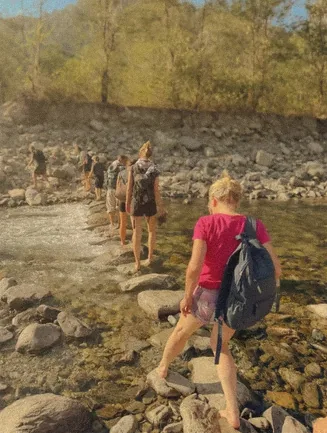 Guests crossing the river on stepping stones